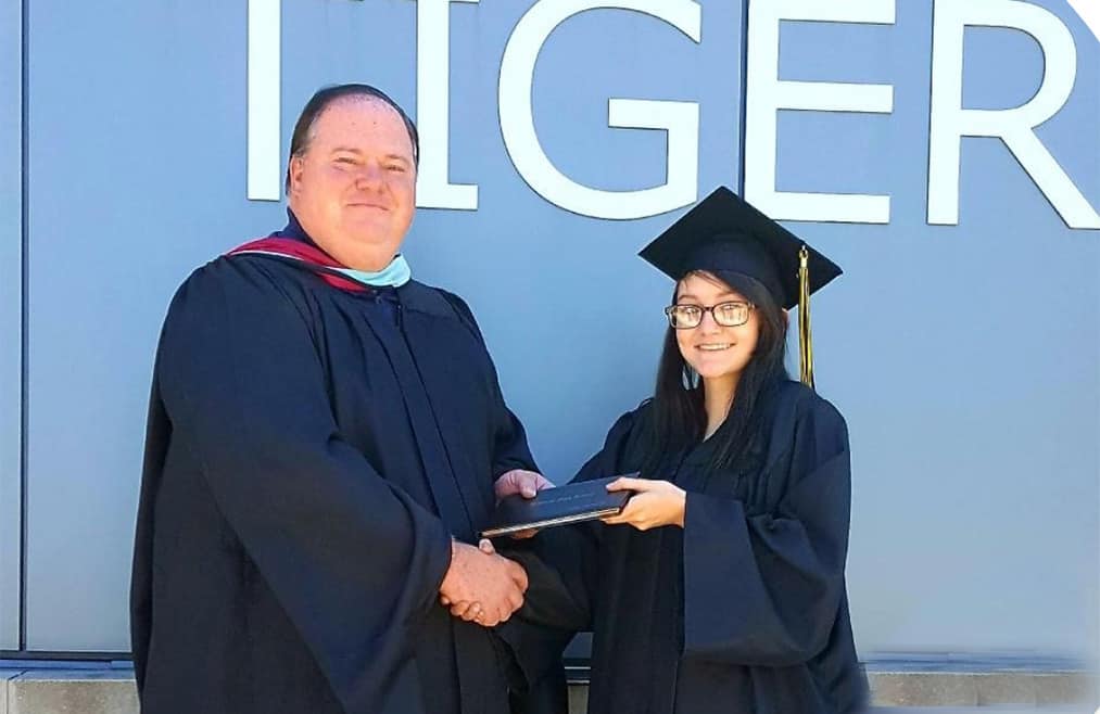 A young high school student receives her diploma.