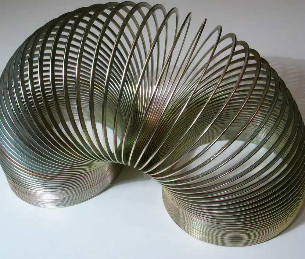 A metal Slinky arched like it is walking